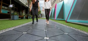 Footstep-powered kinetic energy harvesting tiles generating electricity in a high-traffic public space
